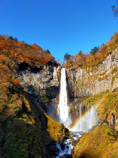 Photo scenic view of waterfall against clear sky during autumn