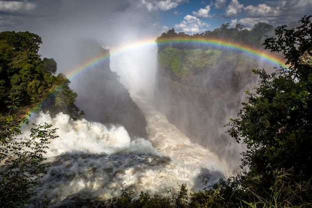 Foto vista panoramica della cascata contro l'arcobaleno nel cielo