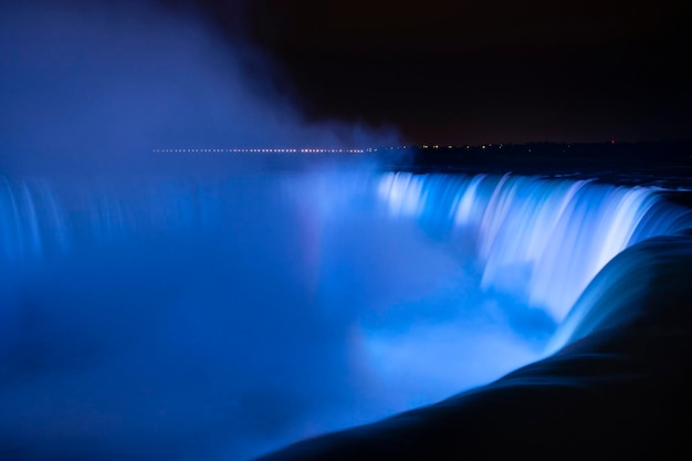 Scenic view of waterfall against sky at night