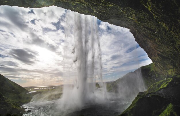 Scenic view of waterfall against sky