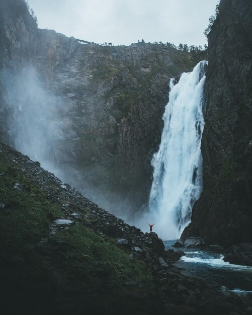 Photo scenic view of waterfall falling from mountain