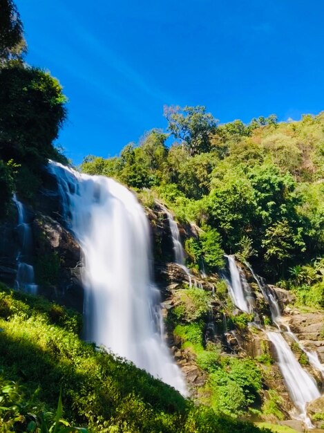 Scenic view of waterfall in forest against sky