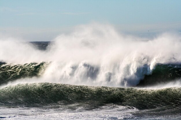 Photo scenic view of waves breaking against sea