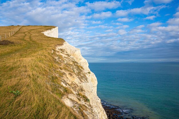 Scenic view of white cliffs with sea on sunny day