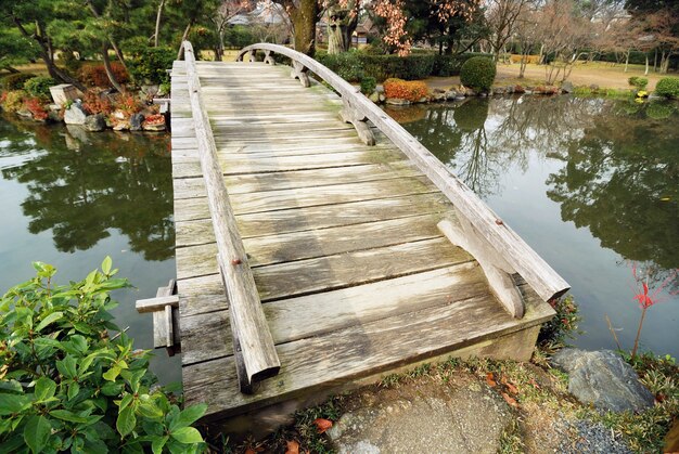 Scenic wooden bridge in Japanese garden at early autumn