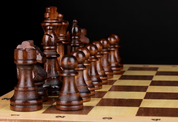 Schaakbord met schaakstukken geïsoleerd op zwart