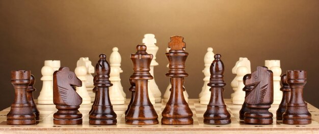 Schaakbord met schaakstukken op bruine achtergrond