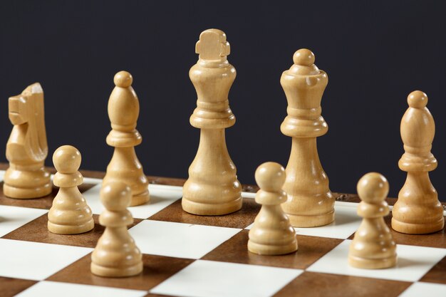 Schaakbord met schaakstukken op grijze achtergrond Selectieve focus op witte koning.