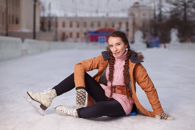 Schaatsen vrouw zittend op het ijs