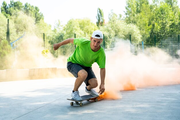 Schaatsers met gekleurde rookbommen. Professionele skateboarders hebben plezier in het skatepark