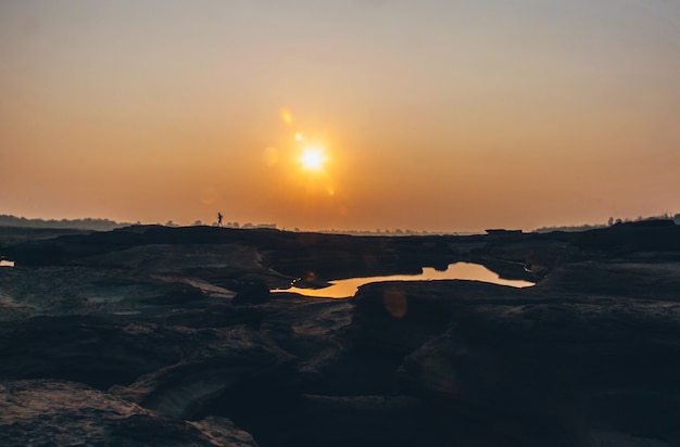 Foto schaduw van een hardloper die door zon en droog land loopt