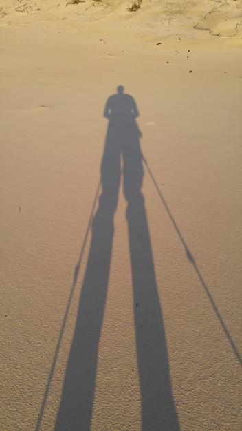 Foto schaduw van een man op het zand op het strand.