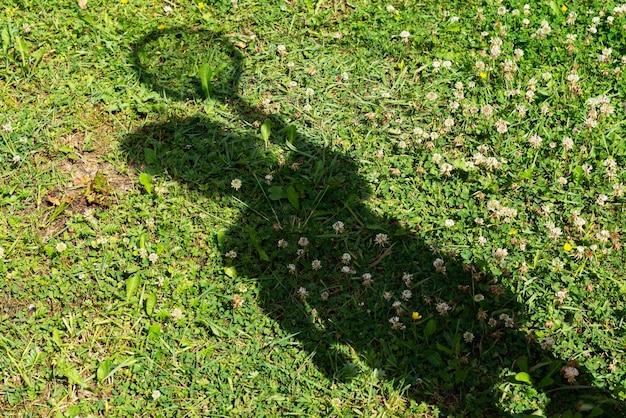 Schaduw van een meisje dat tennis speelt op de grasachtergrond