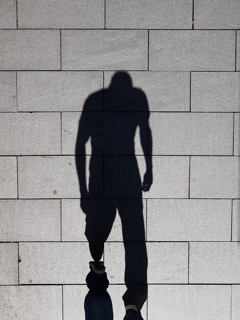 Foto schaduw van mannen die op een zonnige dag op straat lopen