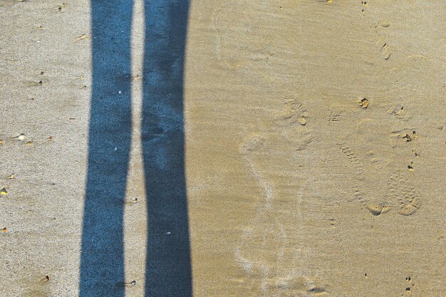 Schaduw van vrouwelijke voeten op natte zand reflectie silhouet voeten op strand