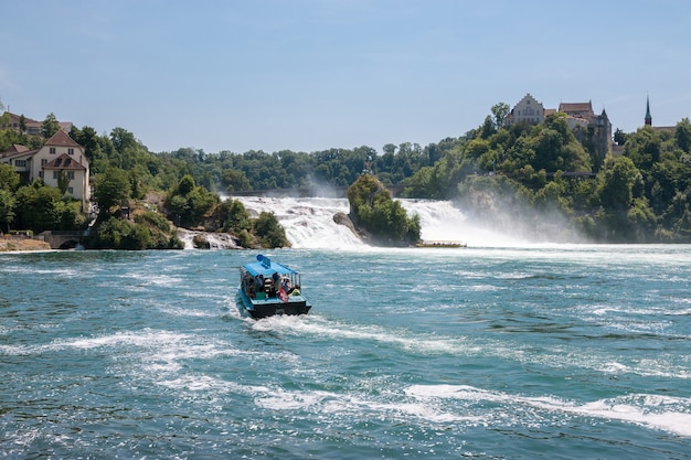 Schaffhausen, Zwitserland - 20 juni 2017: View the Rhine Falls is de grootste waterval van Europa en mensen op boot eromheen. Zomerdag met blauwe lucht