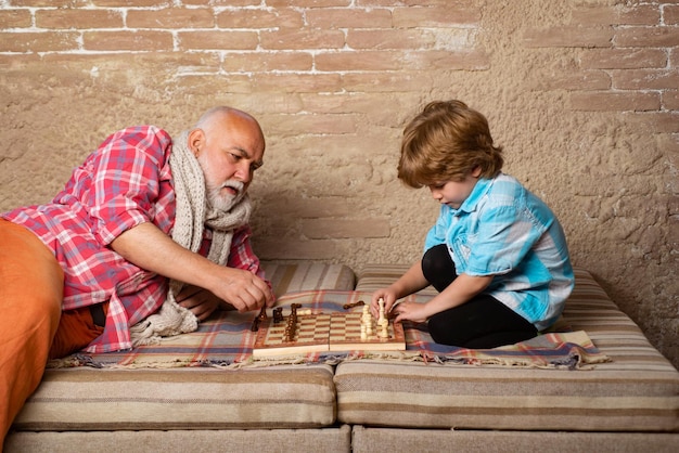Schaken hobby's opa met kleinzoon op een spelend schaak generaties kind dat schaak grootvader speelt pl