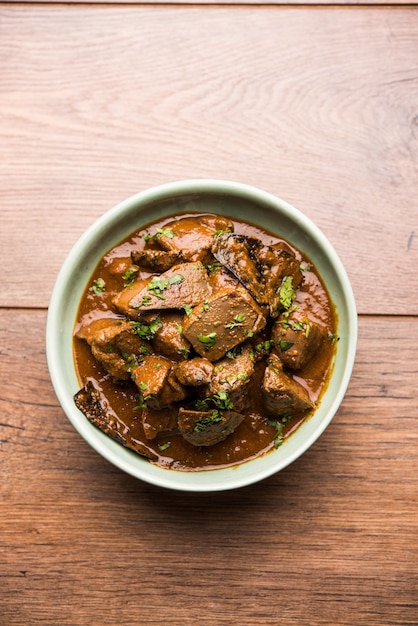 Foto schapenleverbak of kaleji masala, populair niet-vegetarisch recept uit india en pakistan. droog geserveerd of met curry in een kom, karahi of bord