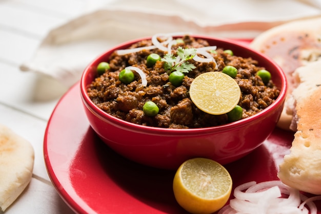 Schapenvlees Kheema Pav OF Indiaas Pittig Gehakt Geserveerd met brood OF Kulcha, gegarneerd met doperwtjes. Humeurige achtergrond. Selectieve focus