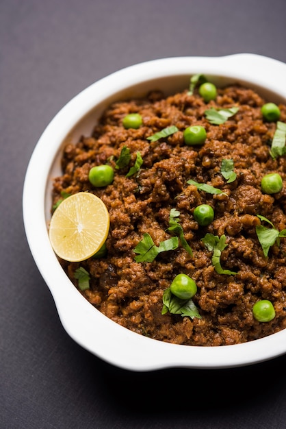 Schapenvlees Kheema Pav OF Indiaas Pittig Gehakt Geserveerd met brood OF Kulcha, gegarneerd met doperwtjes. Humeurige achtergrond. Selectieve focus