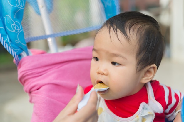 Schattig aziatisch babymeisje dat rijst eet met moeder thailand-mensentijd voor voedsel