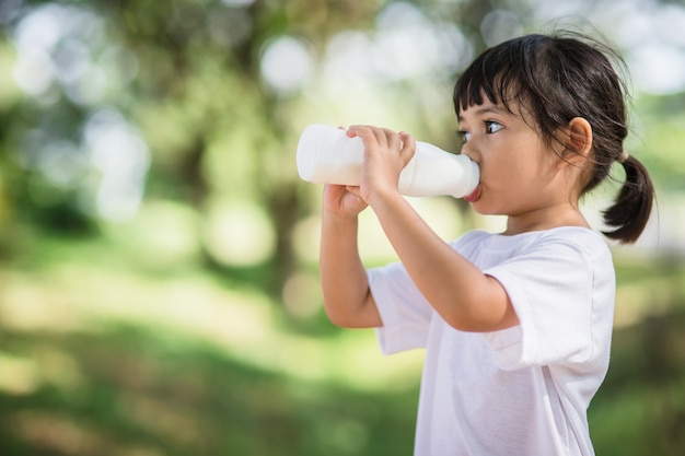 Schattig Aziatisch klein kindmeisje drinkt een melk, soft focus