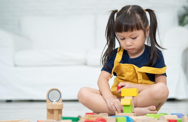 Schattig Aziatisch meisje speelt met kleurrijke speelgoedblokken Kinderen spelen met educatief speelgoed