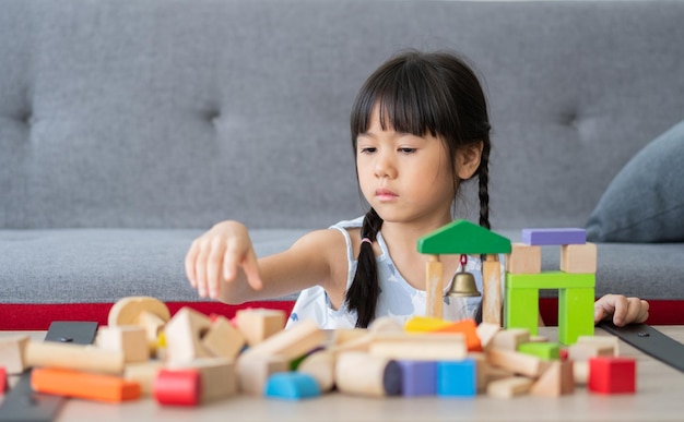 Schattig Aziatisch meisje speelt met kleurrijke speelgoedblokken Kinderen spelen met educatief speelgoed