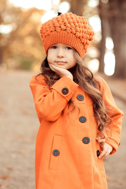 Schattig babymeisje dat buiten loopt met een stijlvolle herfstjas in het park buiten