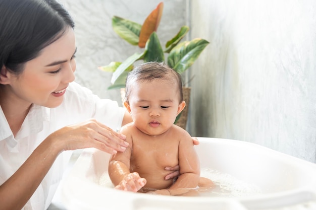 Schattig babymeisje dat een bad neemt met moeder familie kind jeugd en ouderschap concept