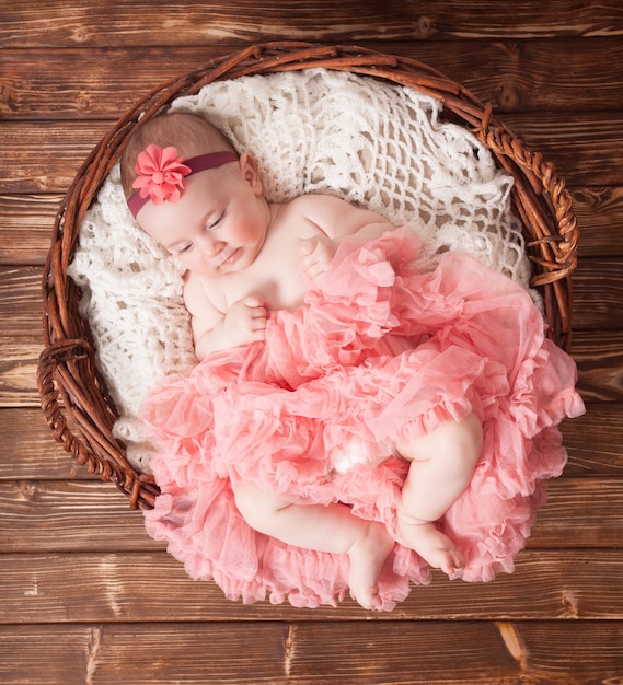 Schattig babymeisje in roze tutu liggend in de mand. Pasgeboren fotografie