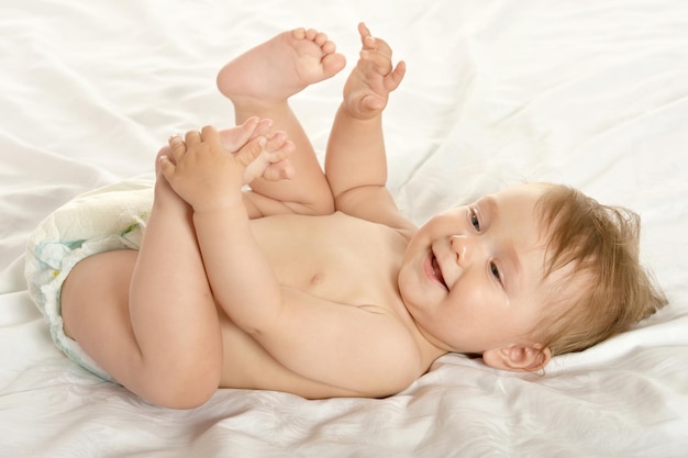 Schattig babymeisje liggend in pampers op deken op een witte achtergrond