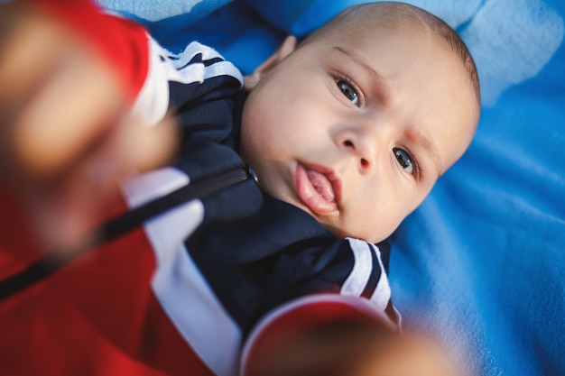 Schattig babymeisje liggend op het gras op een zomerdag. Gezinsactiviteiten met kinderen. Zomerpicknick met een chil