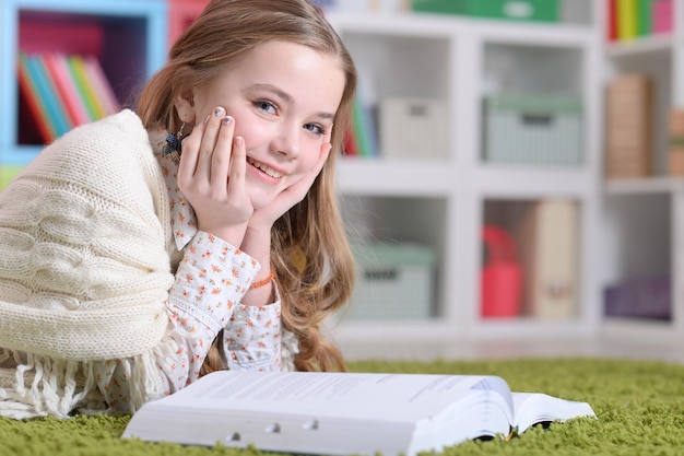 Schattig blij meisje studeren thuis liegen