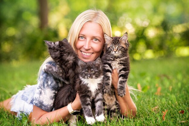 Schattig blond meisje speelt met kleine kittens op warme en zonnige zomerdag