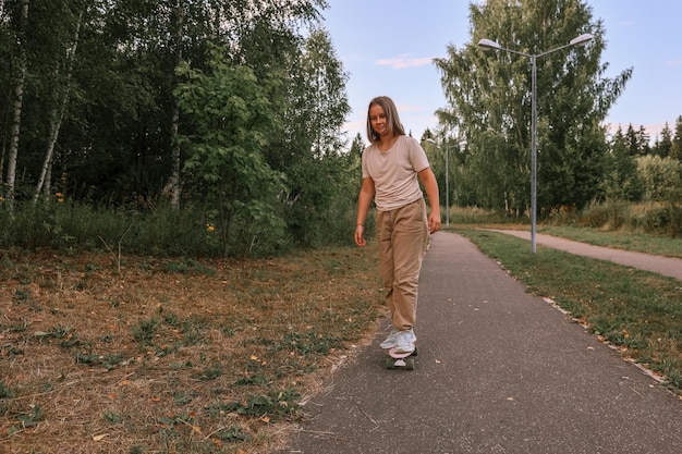 Foto schattig gelukkig meisje skateboard rijden in park
