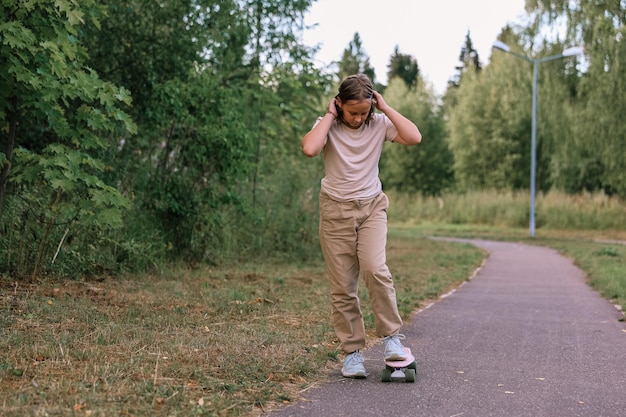 Schattig gelukkig meisje skateboard rijden in park