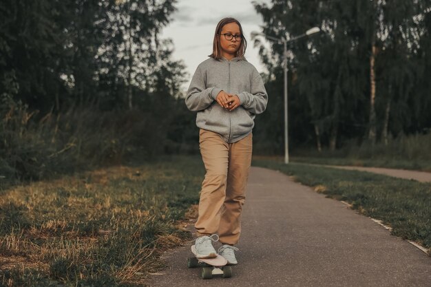 Schattig gelukkig meisje skateboard rijden in park