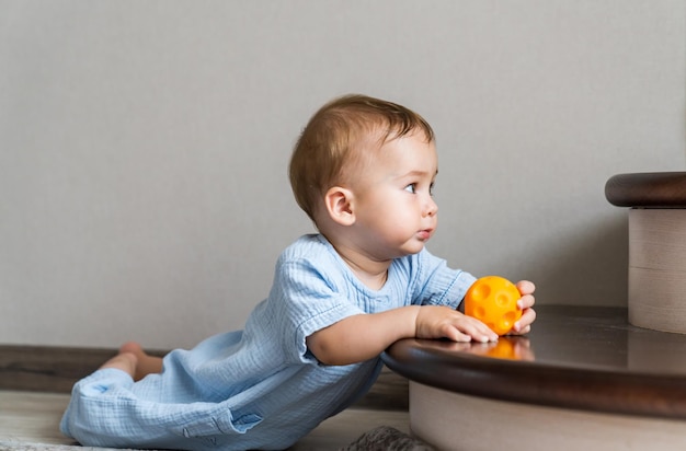 Schattig jong kind dat plezier heeft op de vloer Klein schattig kind dat op de vloer speelt met speelgoed