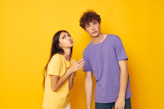 Schattig jong stel in kleurrijke t-shirts poseren vriendschap leuke gele achtergrond ongewijzigd