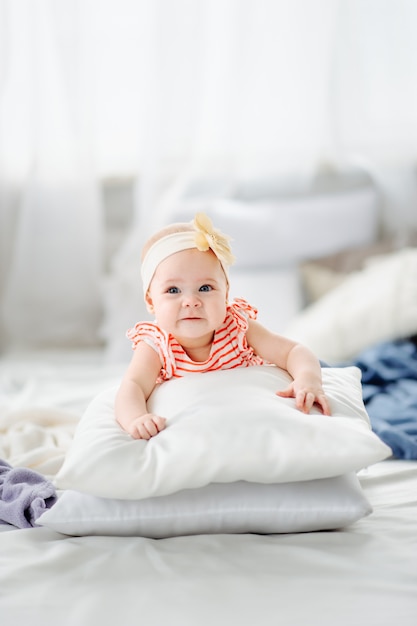 Foto schattig, kaukasisch meisje tot op bed en glimlachen.