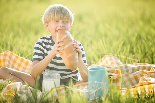 Schattig kind consumptiemelk. Aanbiddelijke jongen die brood eet