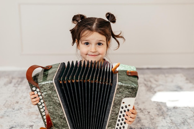 Schattig kind-ID speelt muziekinstrument genaamd harmonica of accordeon