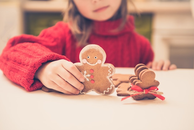 Schattig kind meisje bereidt peperkoek mannen voor kerstvakantie