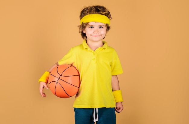 Schattig kind met basketbal Kindjongen speelt basketbal Sportief kind met basketbalbalsport actief