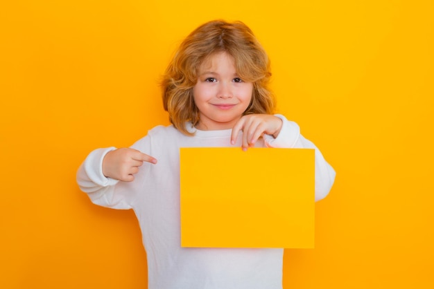 Schattig kind met wijsvinger op vel papier geïsoleerd op gele achtergrond portret van een kind ho