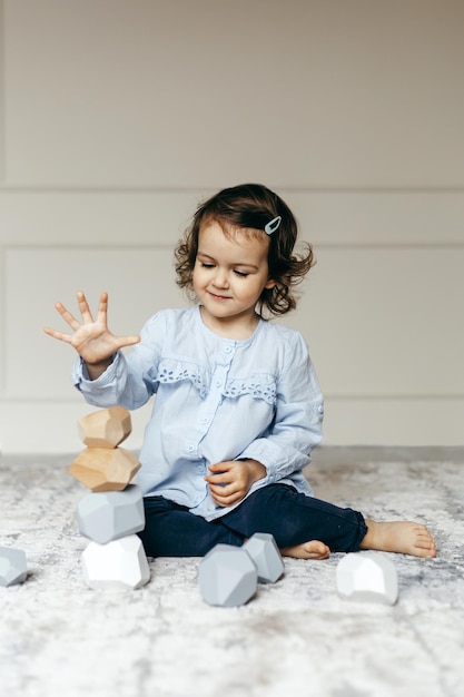 Schattig kind spelen met houten stenen of rotsen genaamd Tumi Ishi uit Japan