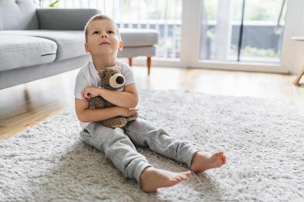 Schattig kind thuis met zijn teddybeer