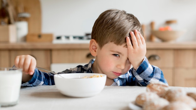 Foto schattig kind wordt moe bij het ontbijt