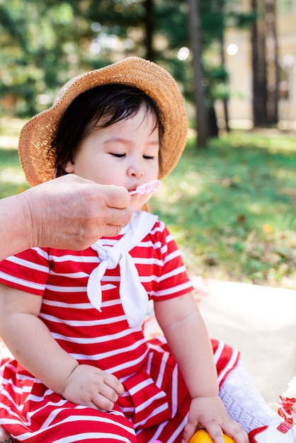 Schattig klein Aziatisch meisje in een gestreepte jurk in de natuur